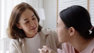 mother, face to face with teenage daughter, engaged in serious conversation