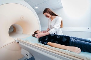 technician prepares boy for a brain scan
