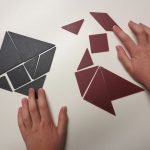 child's hands assembling a tangram figure