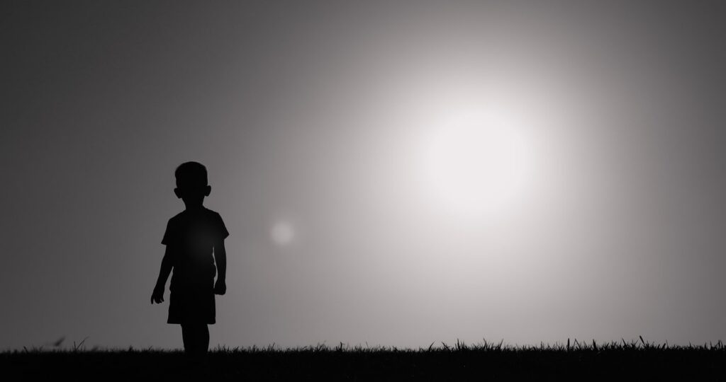 silhouette of young body standing alone in a field