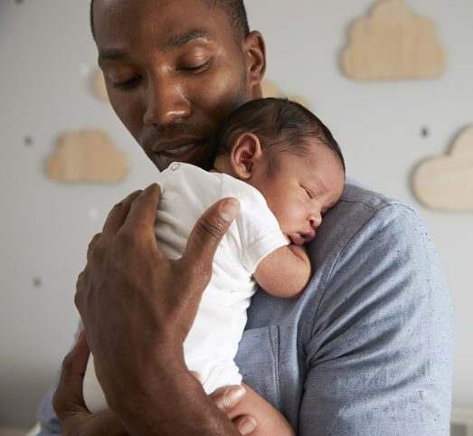 father holding sleepy infant