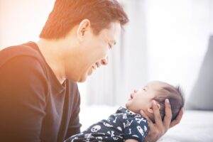father smiles, face-to-face communication with newborn