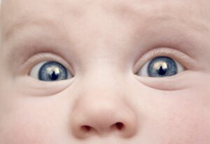 baby with dilated pupils and intense expression - showing emotional contagion