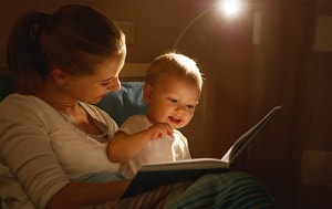 mother reading to baby at night
