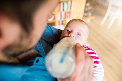 father bottle-feeding baby