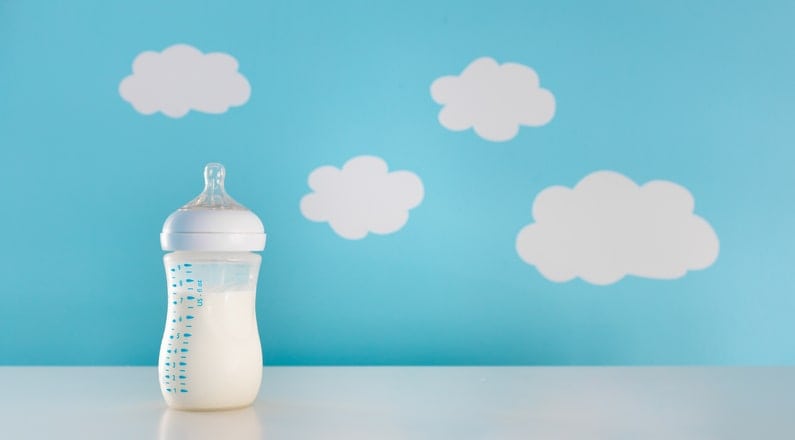 bottle of breast milk against cheerful background