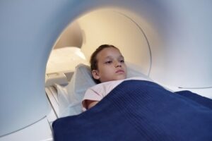 child lying on table and about to enter an fMRI machine