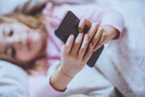 Child using phone in bed - does screen time cause sleep problems?