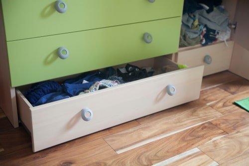 chest of drawers, with bottom drawer standing open -- contents unclear