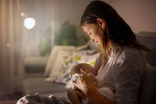 mother breastfeeding newborn at night