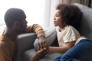 emotion coaching: Father talking sensitively with young daughter