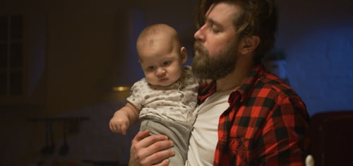 exhausted father holding infant