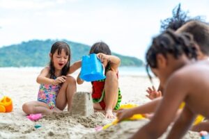 children making sandcastles on the beach