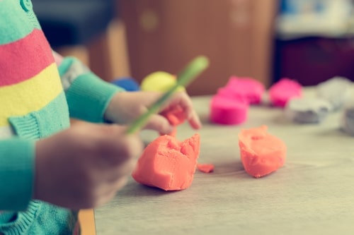 closeup of preschooler's hands - creating something with craft clay