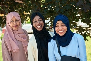 three teen girls wearing religious headdress, smiling