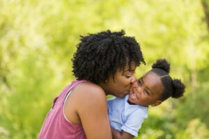 mother kissing happy toddler