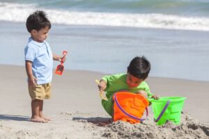 two young boys making sand castles on the beach