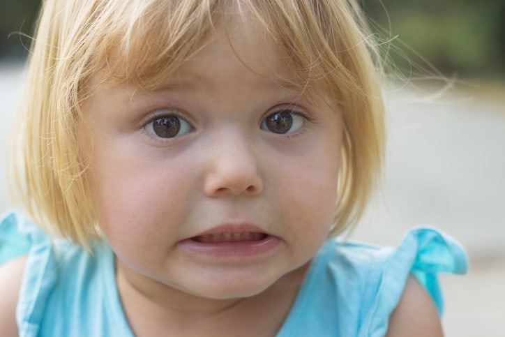 toddler girl making uncertain facial expression