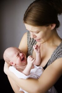 distressed mother holds crying infant
