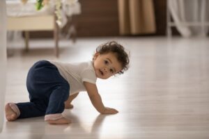 baby looking over shoulder while learning to crawl