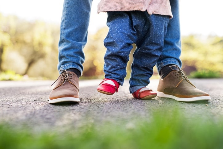 toddler feet walking alongside adult feet