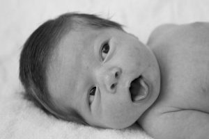 newborn looking sideways at something, mouth open
