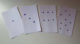 four cards, each displaying a different number of dots